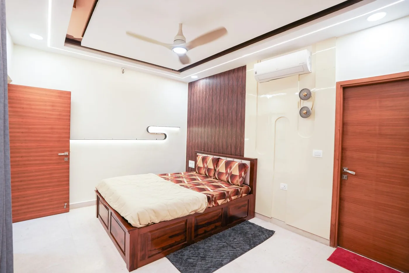 Bedroom by Candidscape at RMZ City View, Bangalore, with a fluted wood feature panel, a wooden storage bed and wood-finish doors