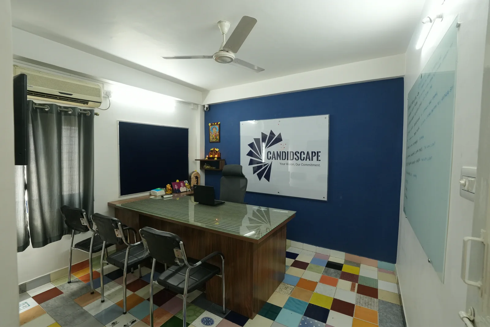 Consultation cabin at the Candidscape design studio on New BEL Road, Bangalore, with a meeting desk, chairs and a glass writing board
